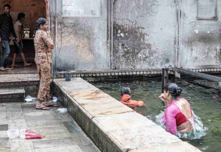 women and men take shower in pool of the temple.