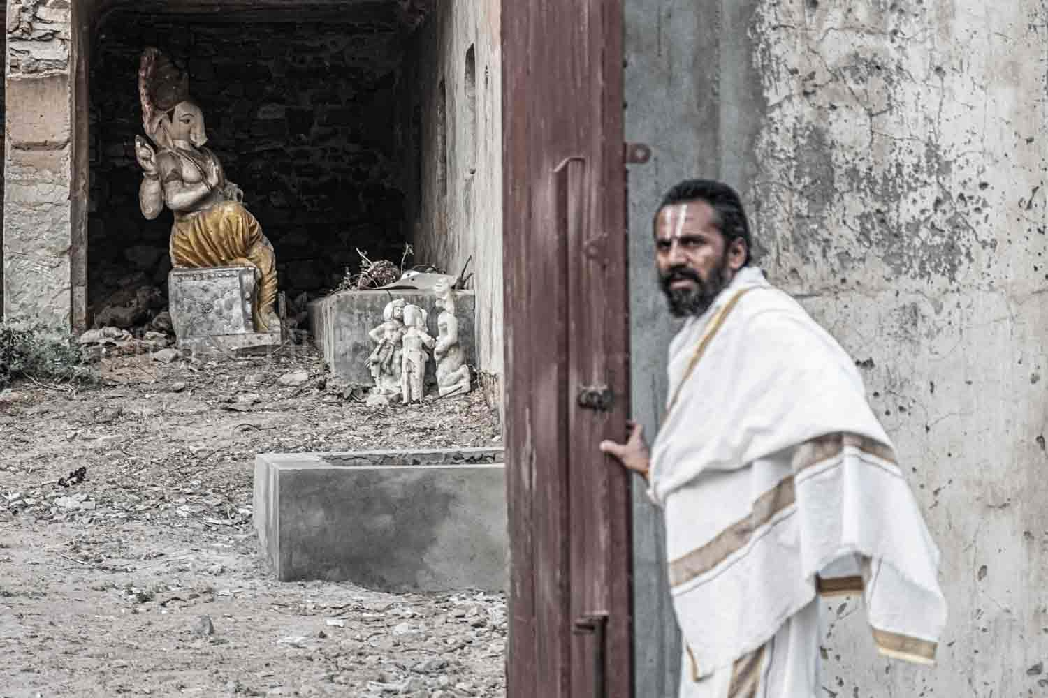 A monk close the door where hey put the broken status of Shiva.